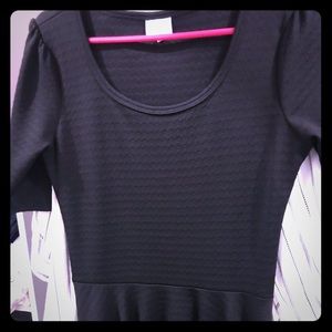 Black dress with understated pattern.